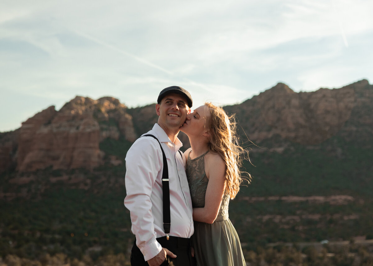 Couple standing against red rock backdrop during Sedona engagement session
