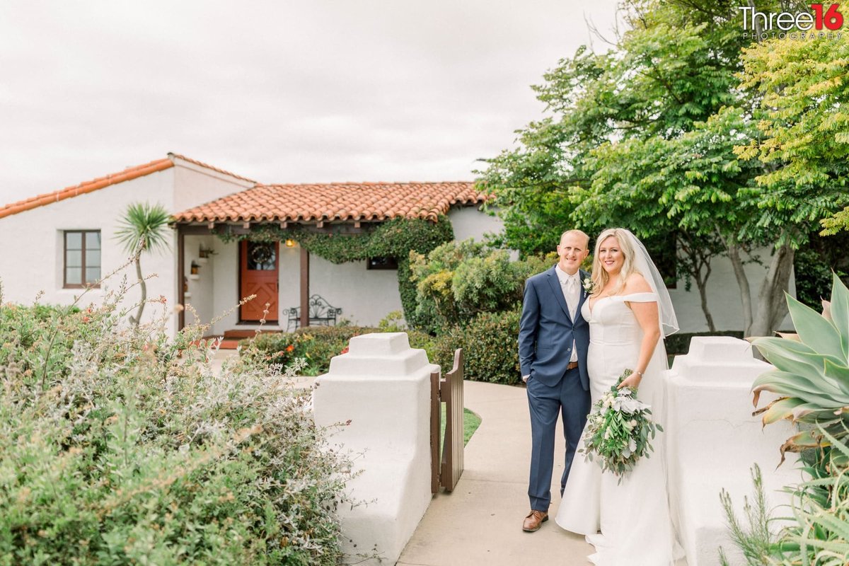 Newly married couple pose together outside the Historic Cottage wedding venue in San Clemente, CA