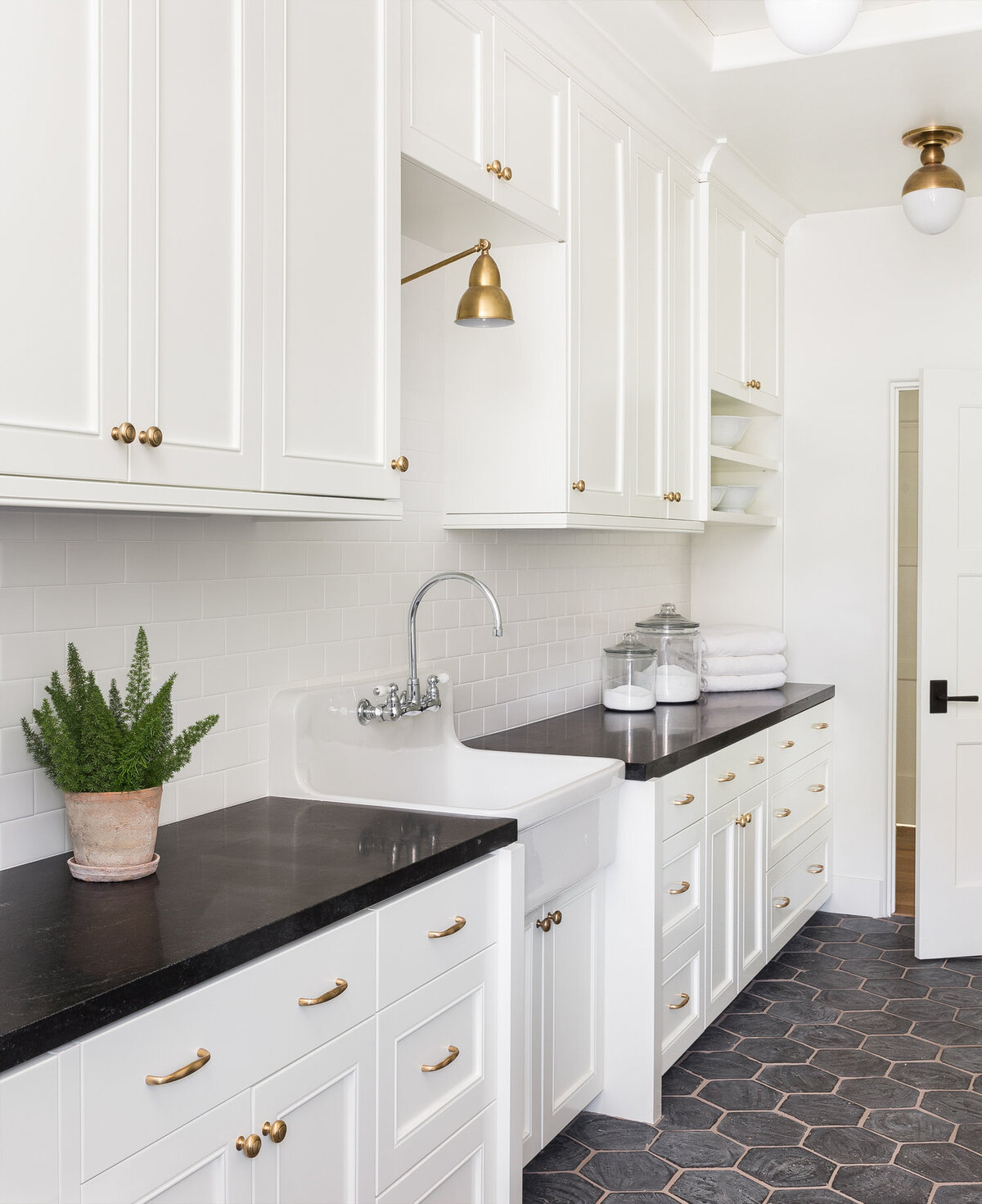 bright-laundry-room-farmhouse-sink-black-countertops