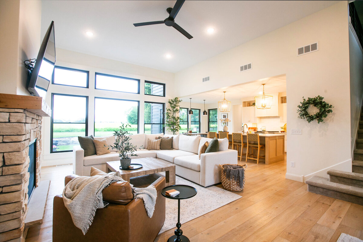 Cozy living room in Otsego custom home with fireplace, built-ins, and large windows