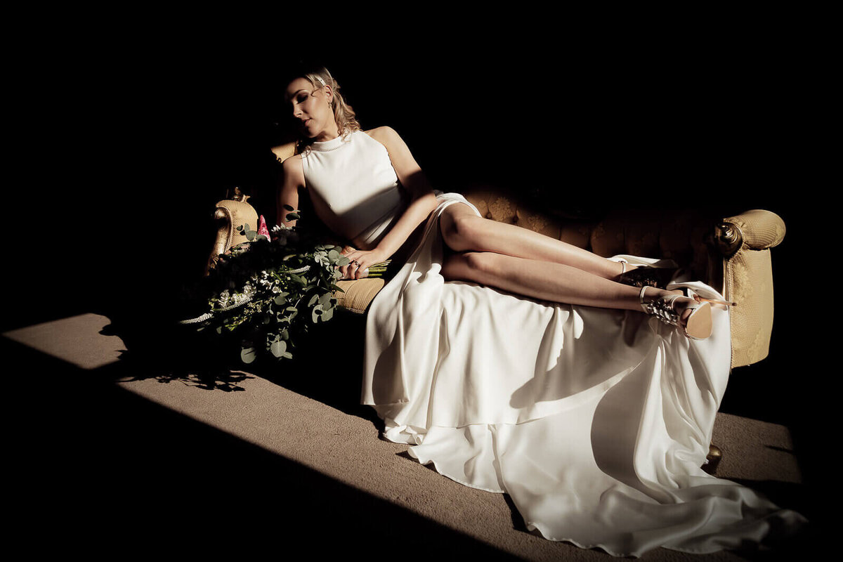 A bride at Errol Estate on a chez long, sun beams highlight her and her bouquet.