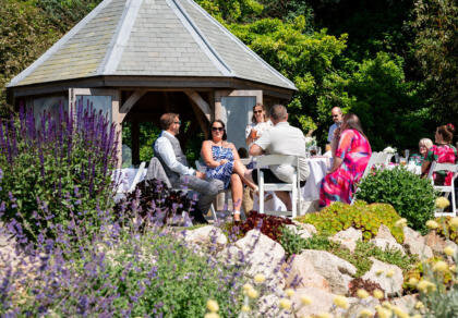 A group of wedding guests sitting around a gazebo