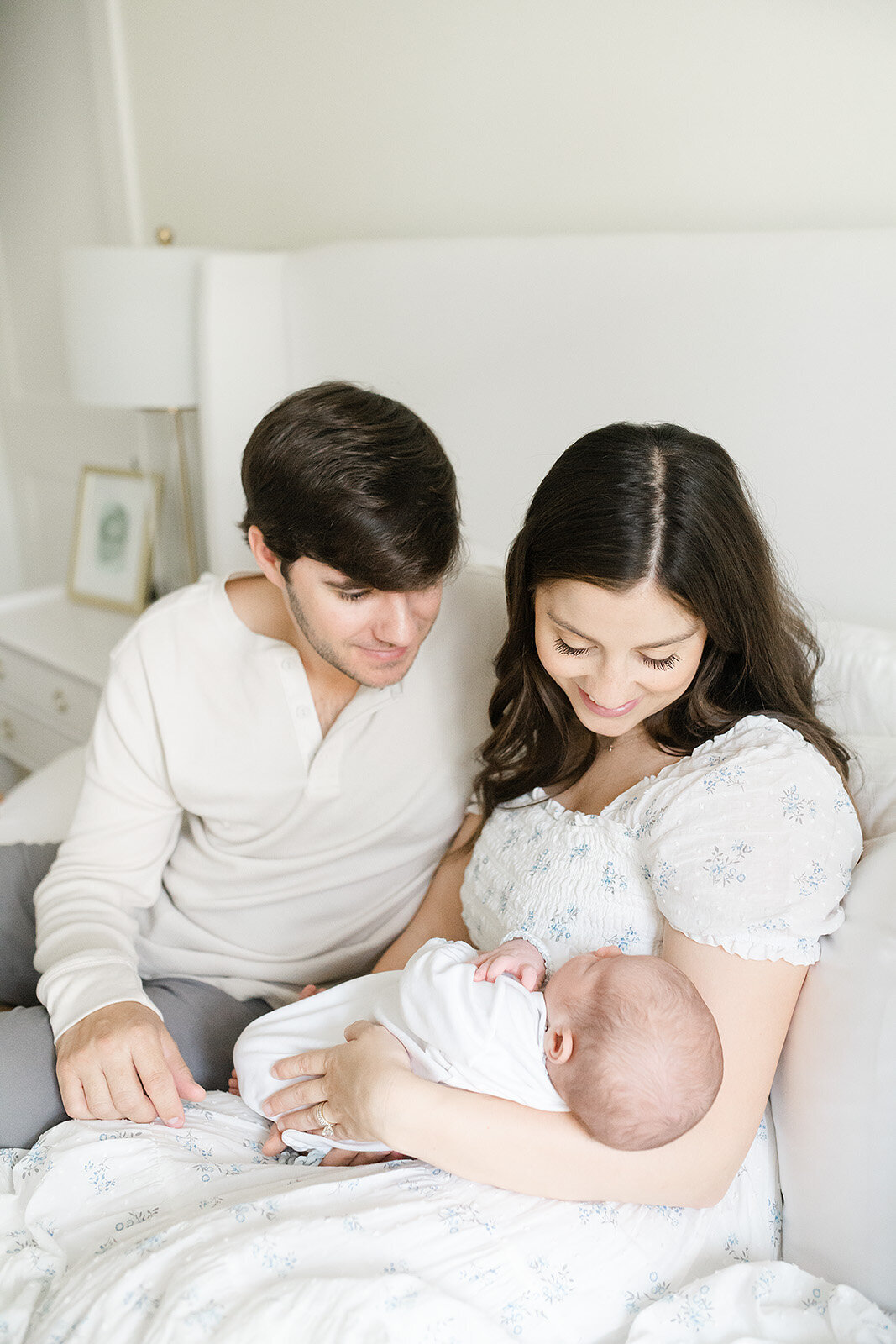 parents with their newborn on a bed