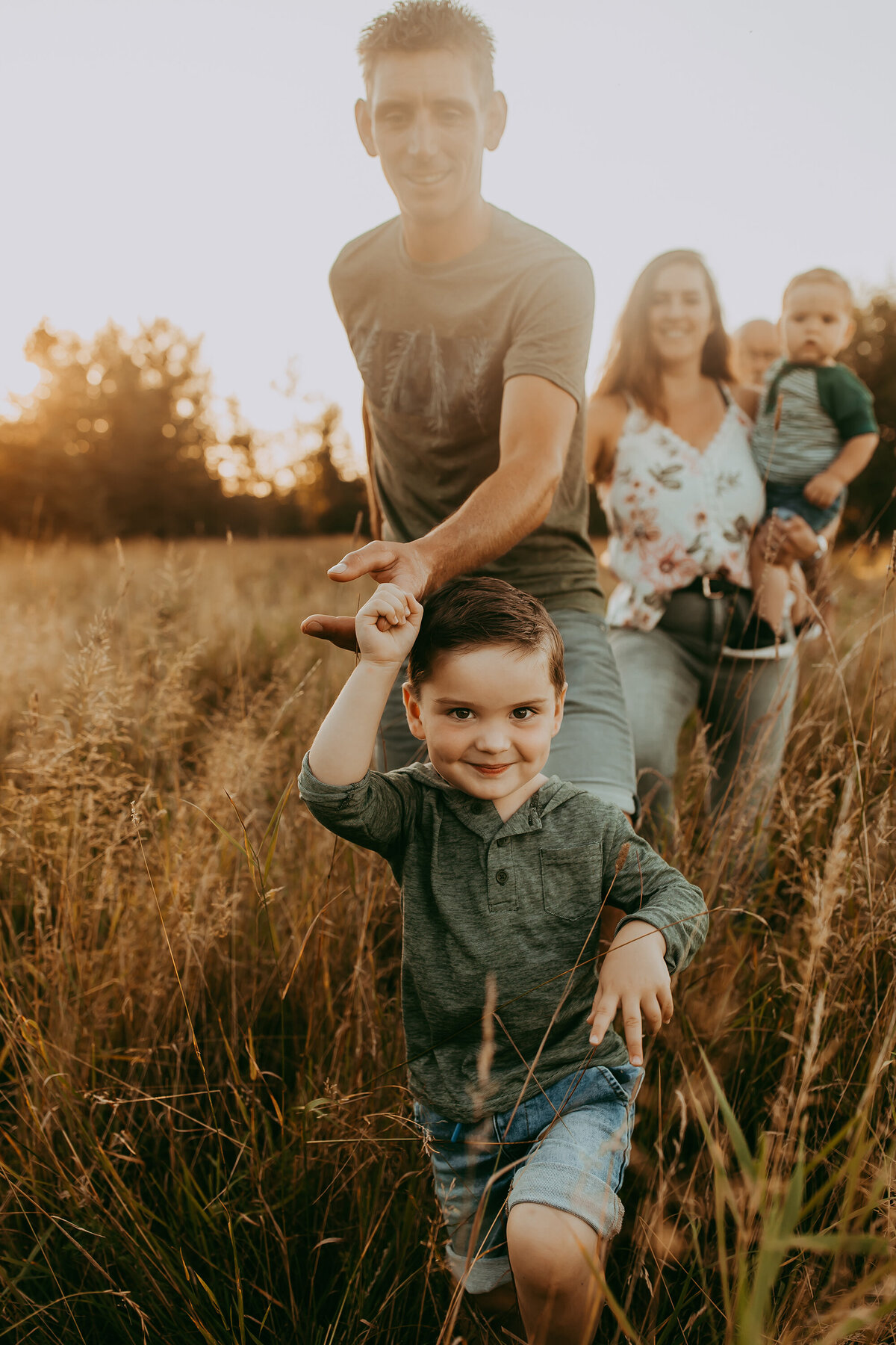 family-walking-through-field-portrait