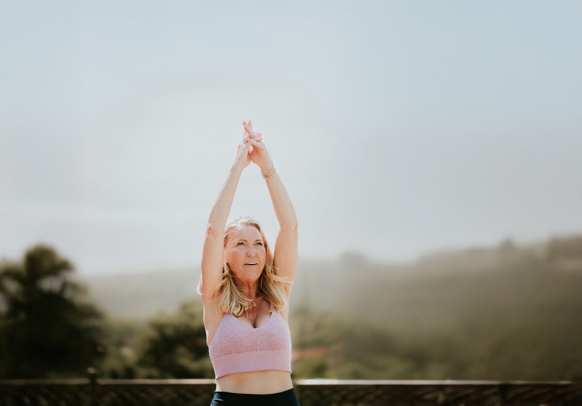 Personal brand image of 50+ yoga instructor Amy Witte looking grounded and confident on her mat.