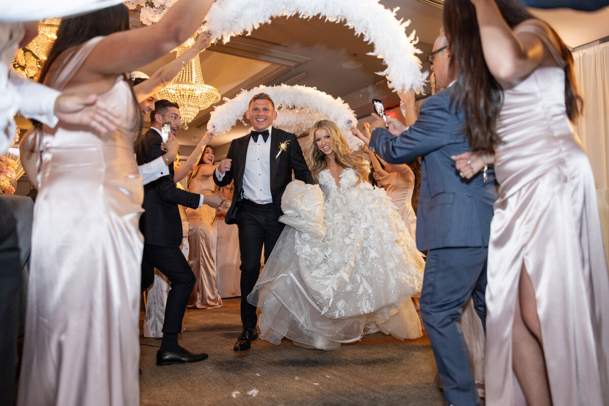 A bride and groom walking through a tunnel of their wedding guests