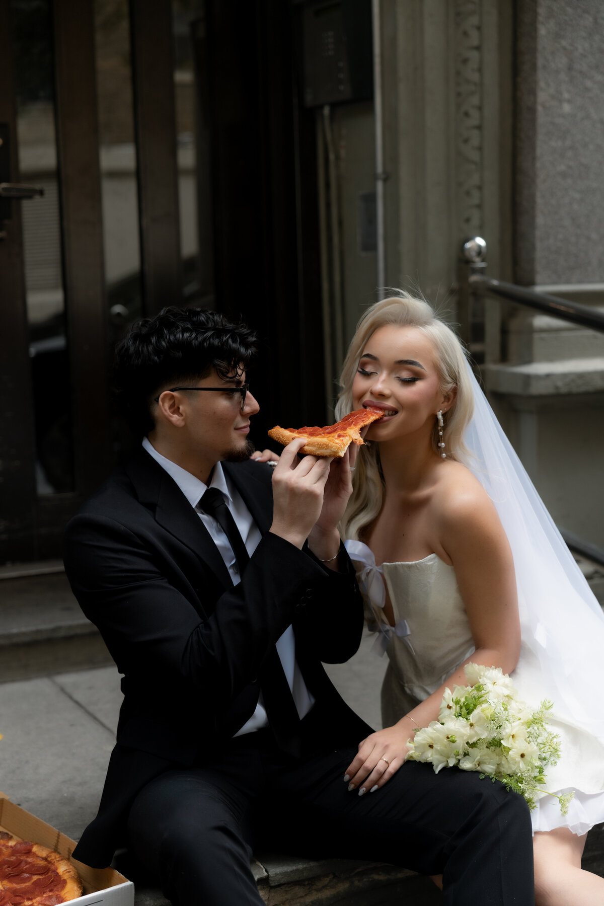 A candid photo of the couple playing with pizza slices in NYC.