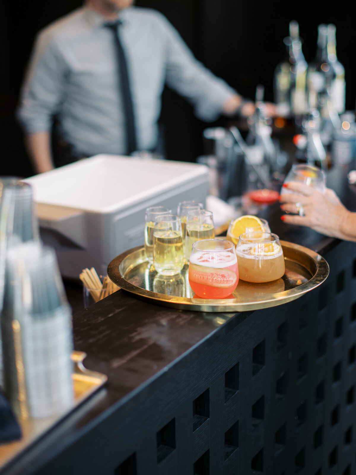 A gold tray of cocktails on the black bar