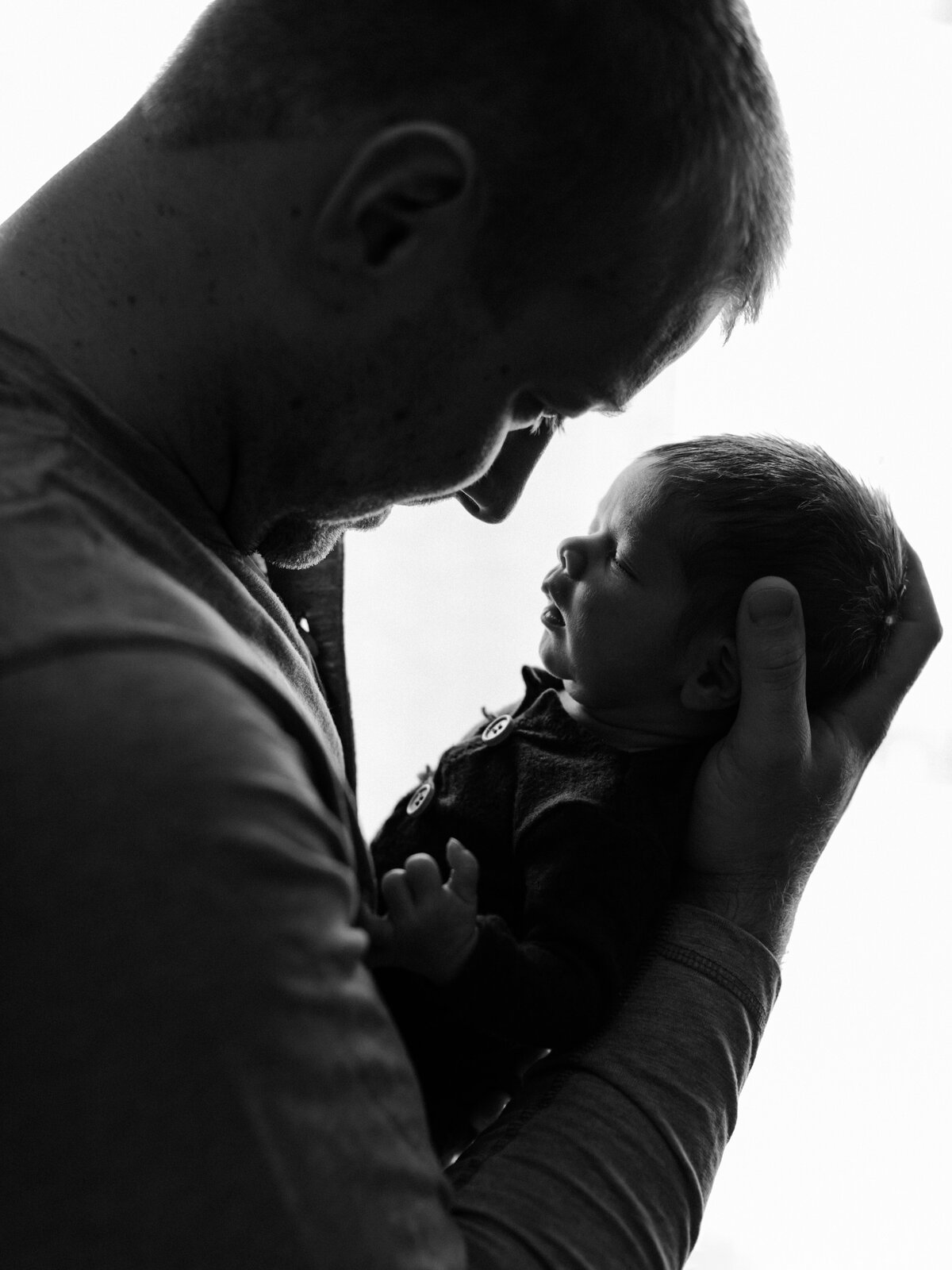 dad holding newborn son for in home lifestyle session cleveland newborn photographer