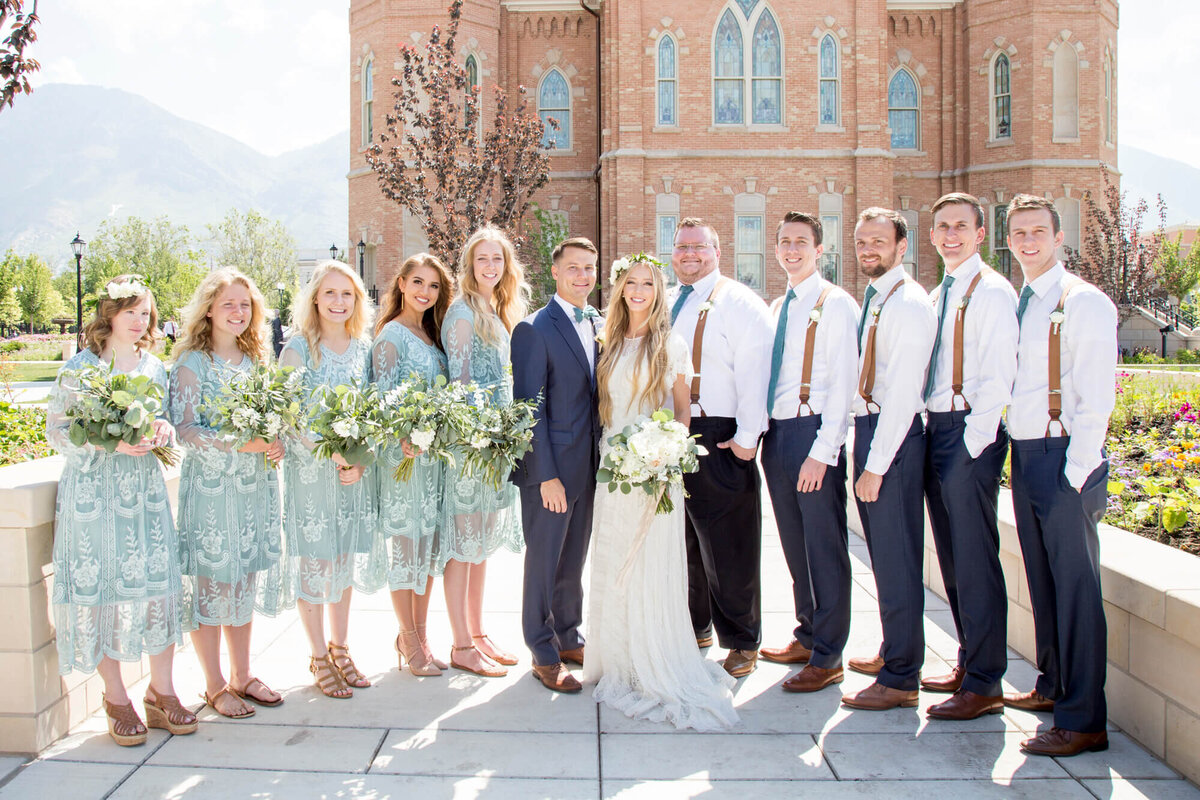 a bride and groom with a wedding party on a bright sunny day