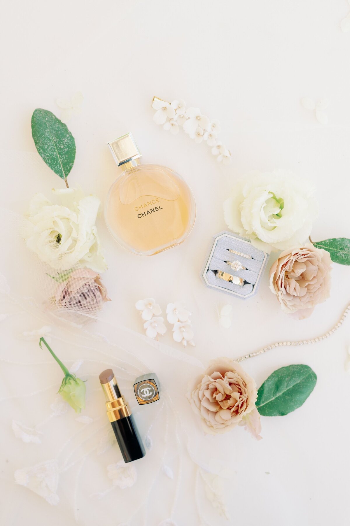 wedding rings, a perfume bottle, and flowers