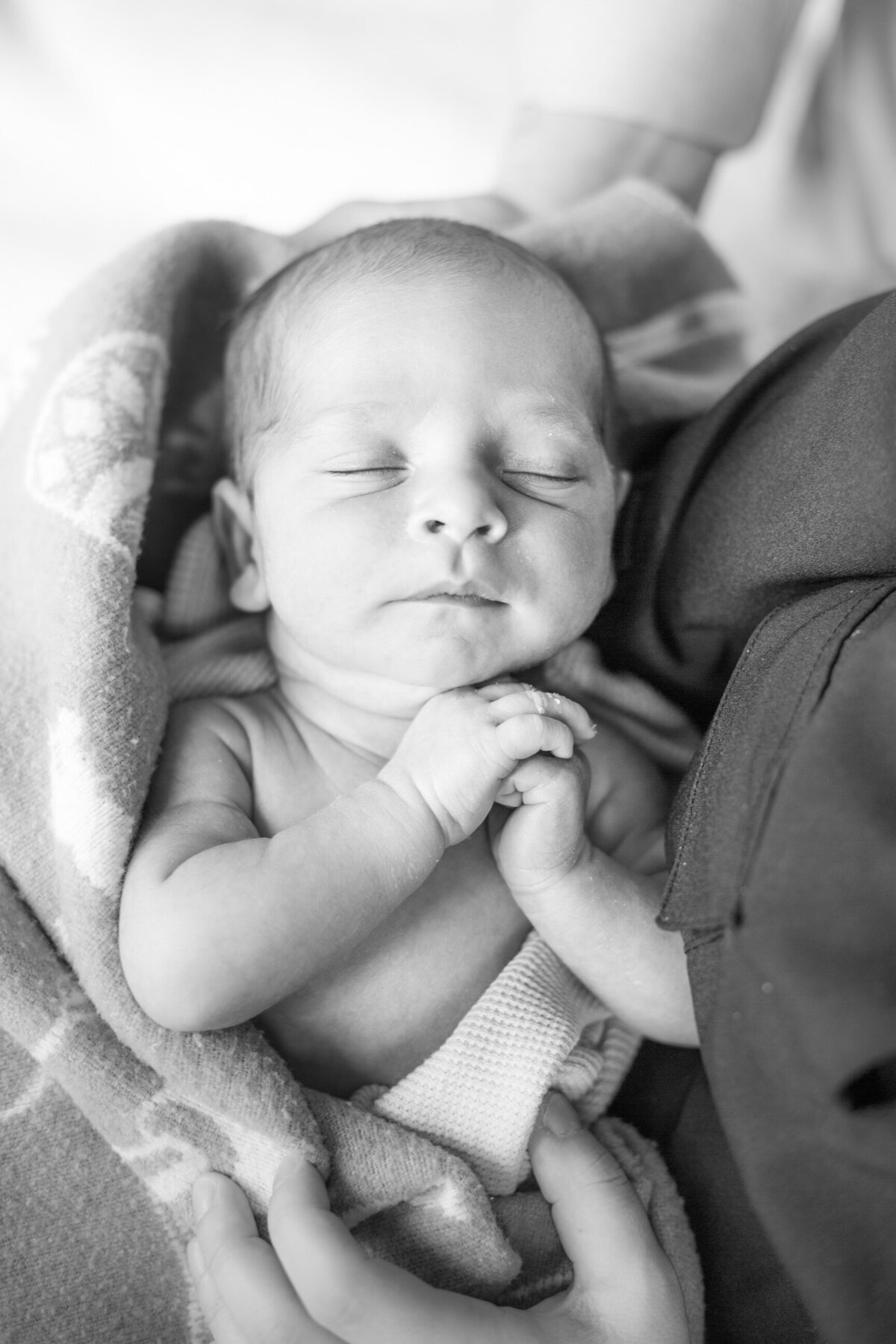 newborn sleeping in moms arms