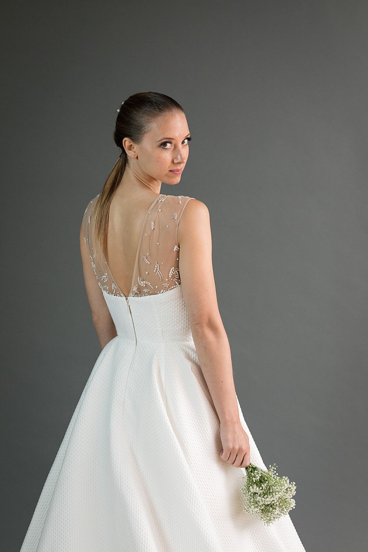A close-up of the illusion V-back on the Kei modern ballgown wedding dress that sits under the strapless bodice.