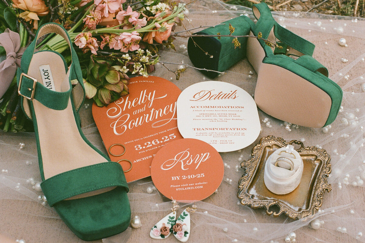 A detail oriented shot with shoes, RSVPs, earrings, and wedding bands