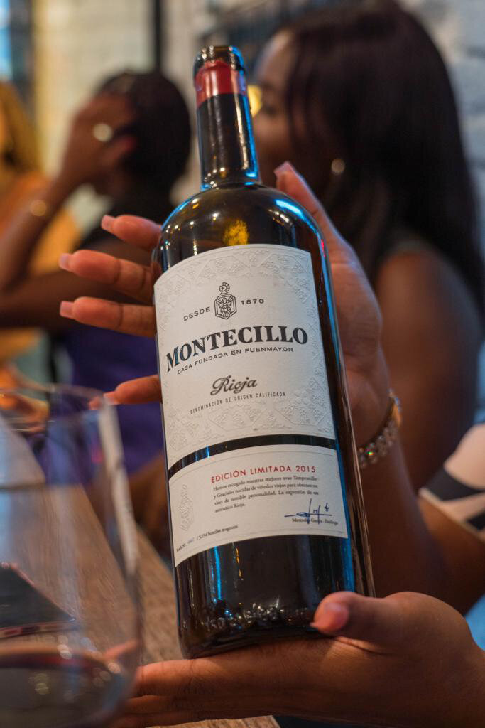 A bottle of Montecillo wine held by a guest at Wine Guide Madrid's Tapas and Wine Experience.