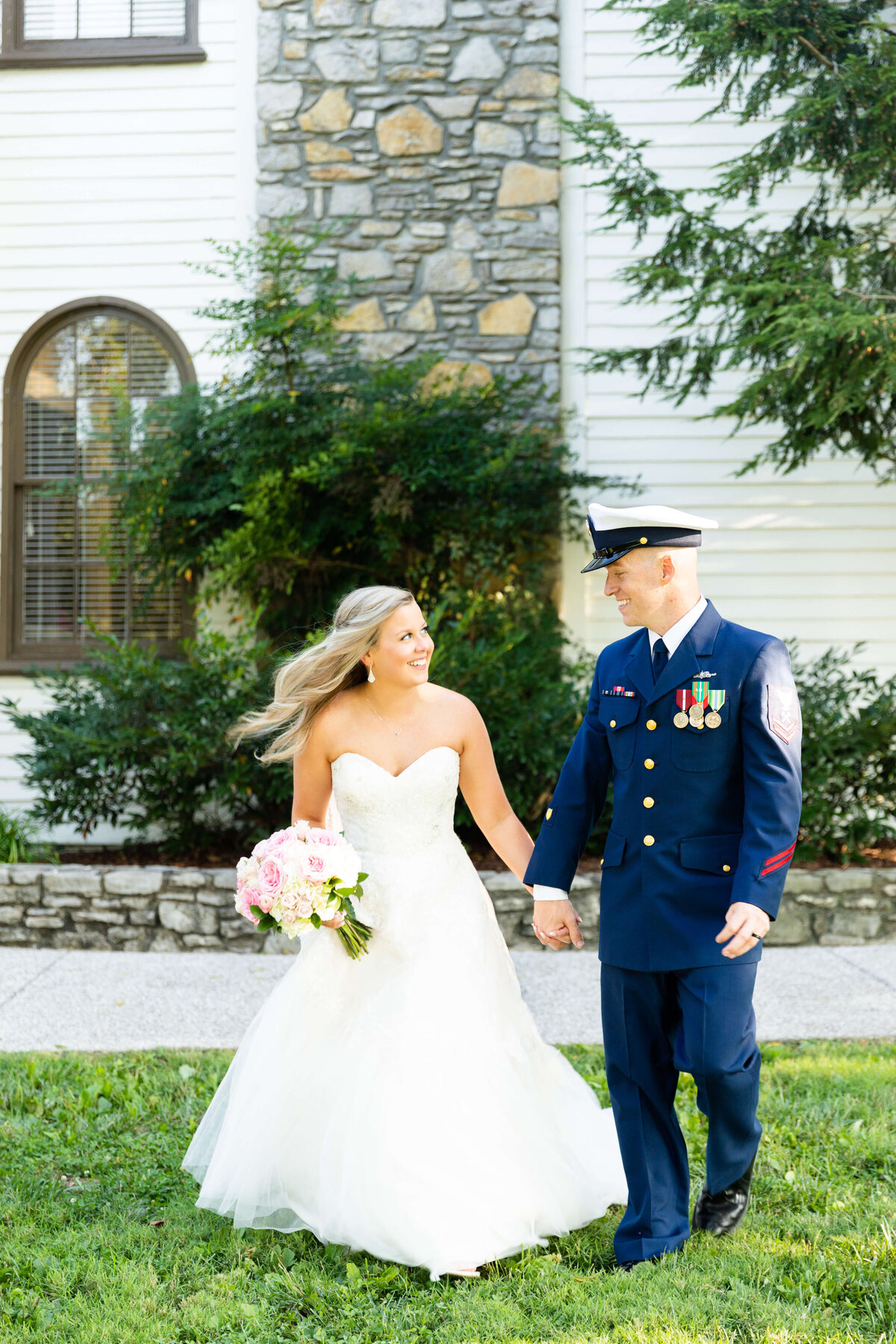 Bride and groom walking along hollding hands at Nashville wedding