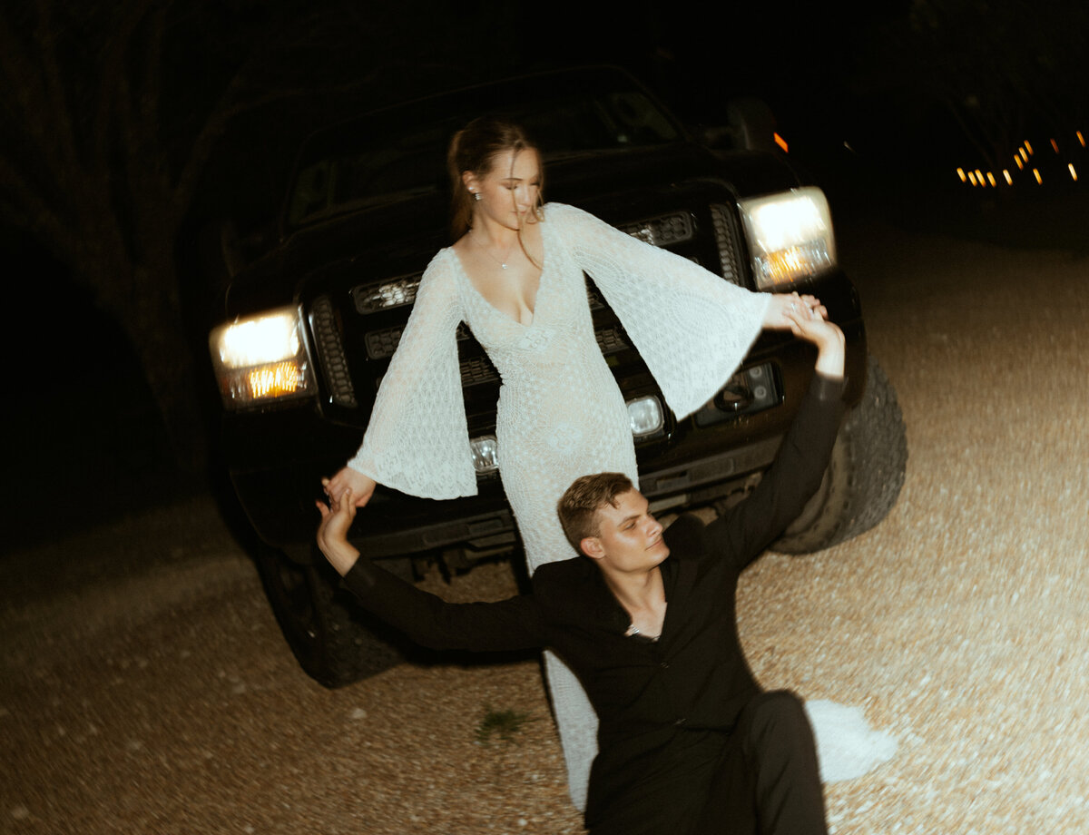 bride and groom in front of car