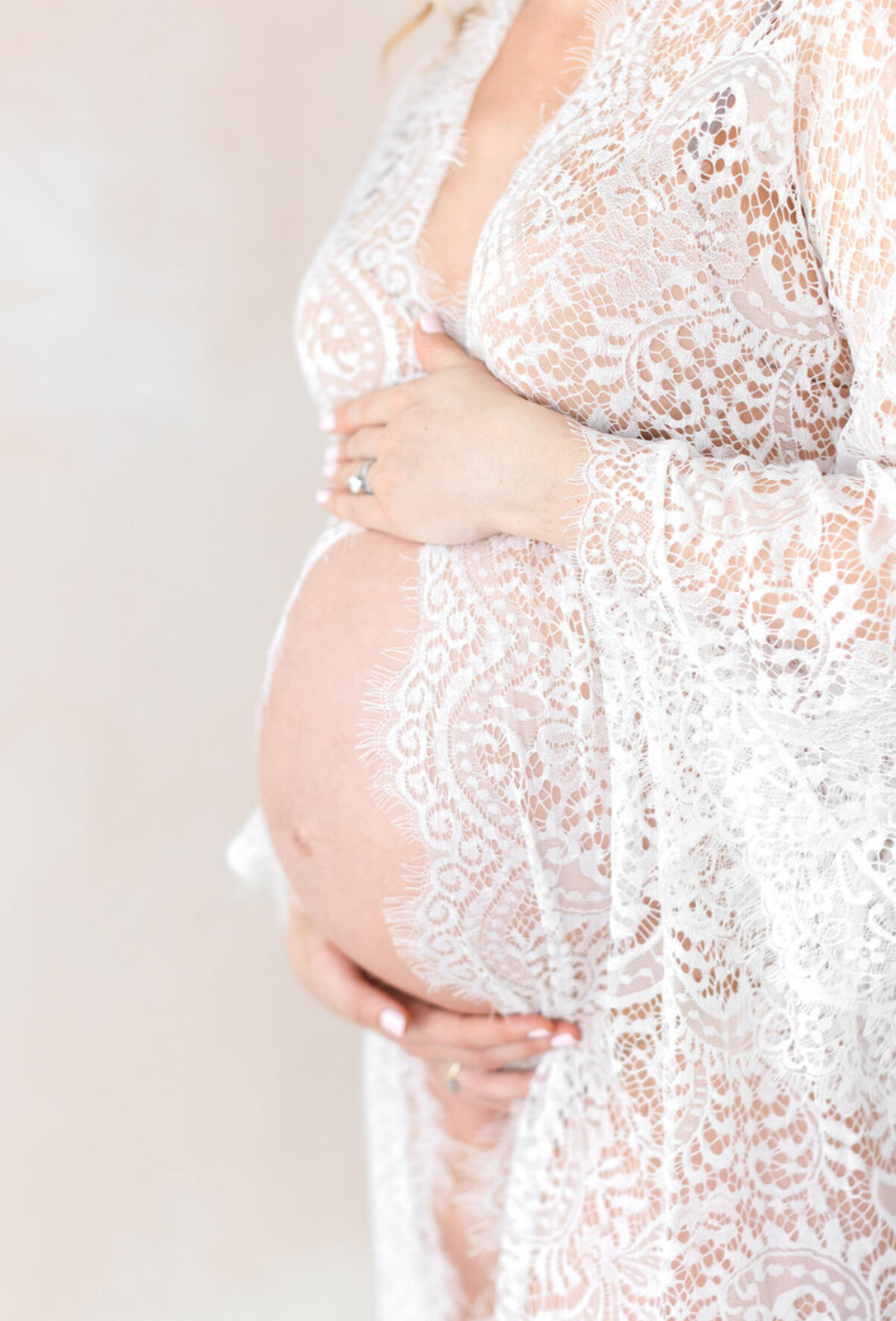 36 week pregnant mom wearing a seen through gown to show pregnant belly.