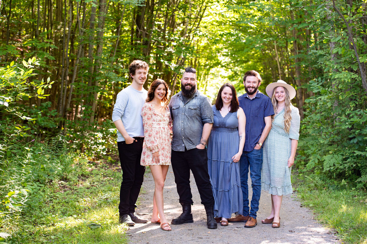 adult siblings together and laughing outdoors in the woods as part of their family photography session in Ottawa