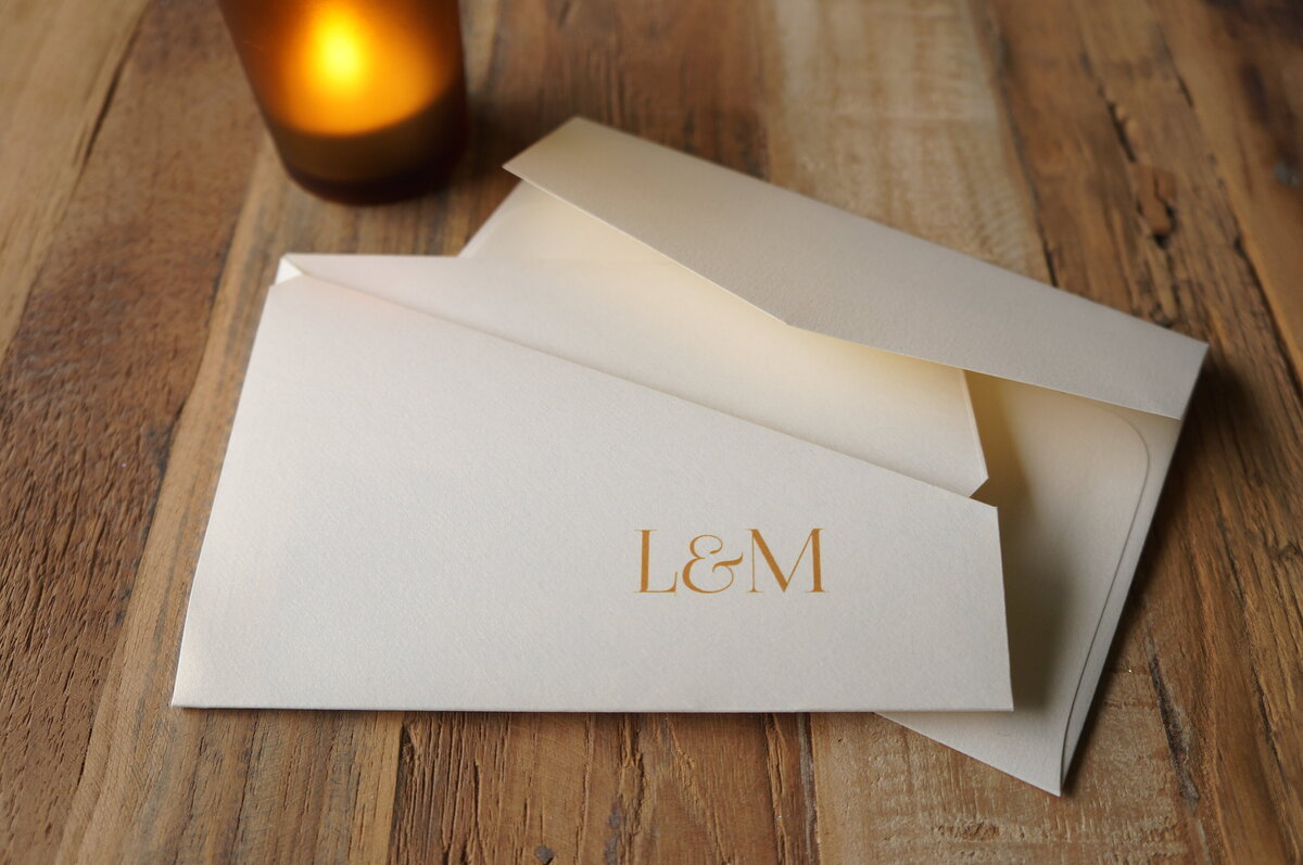Origami wedding invitation with ivory paper and couples initials on the front printed in gold