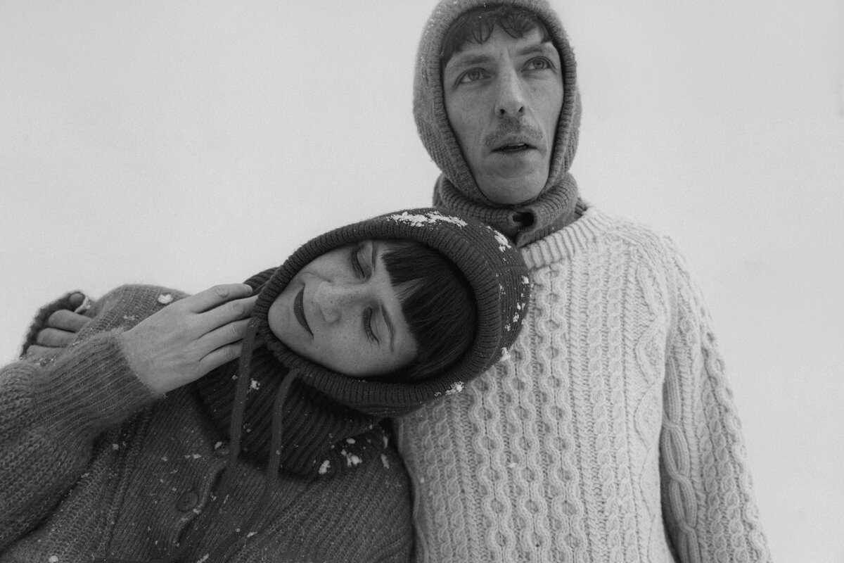 Black and white portrait of a couple under the snow in Old Montreal