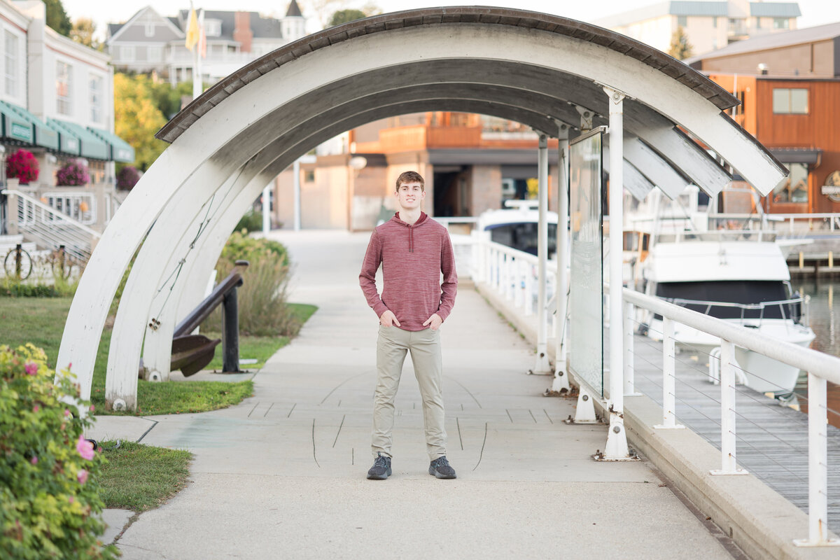 Senior guy standing under a structure smiling at the camera