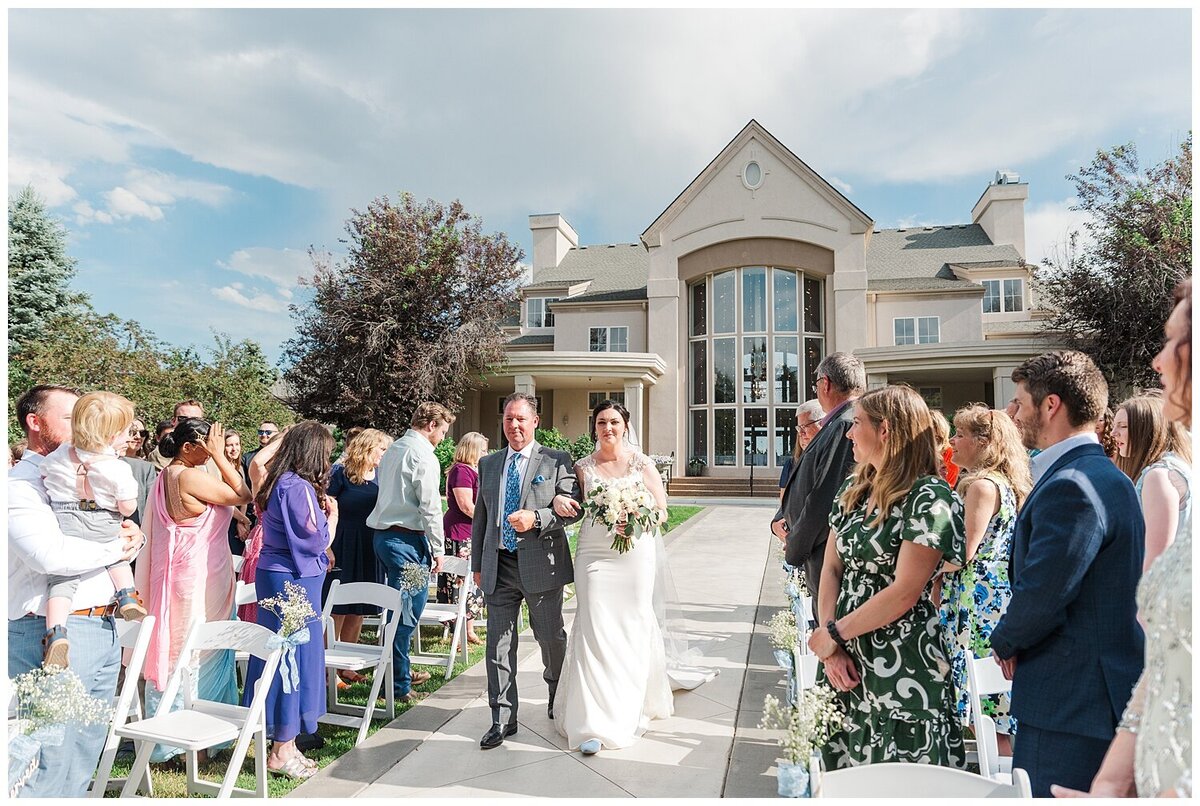 a bride walks down the isle with her dad as they make their way together to the groom standing at the alter at chateaux at fox meadows captured by denver wedding photographer