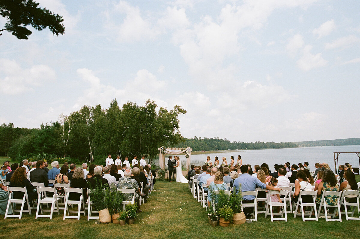wedding ceremony taking place on the shore of a minnesota lake