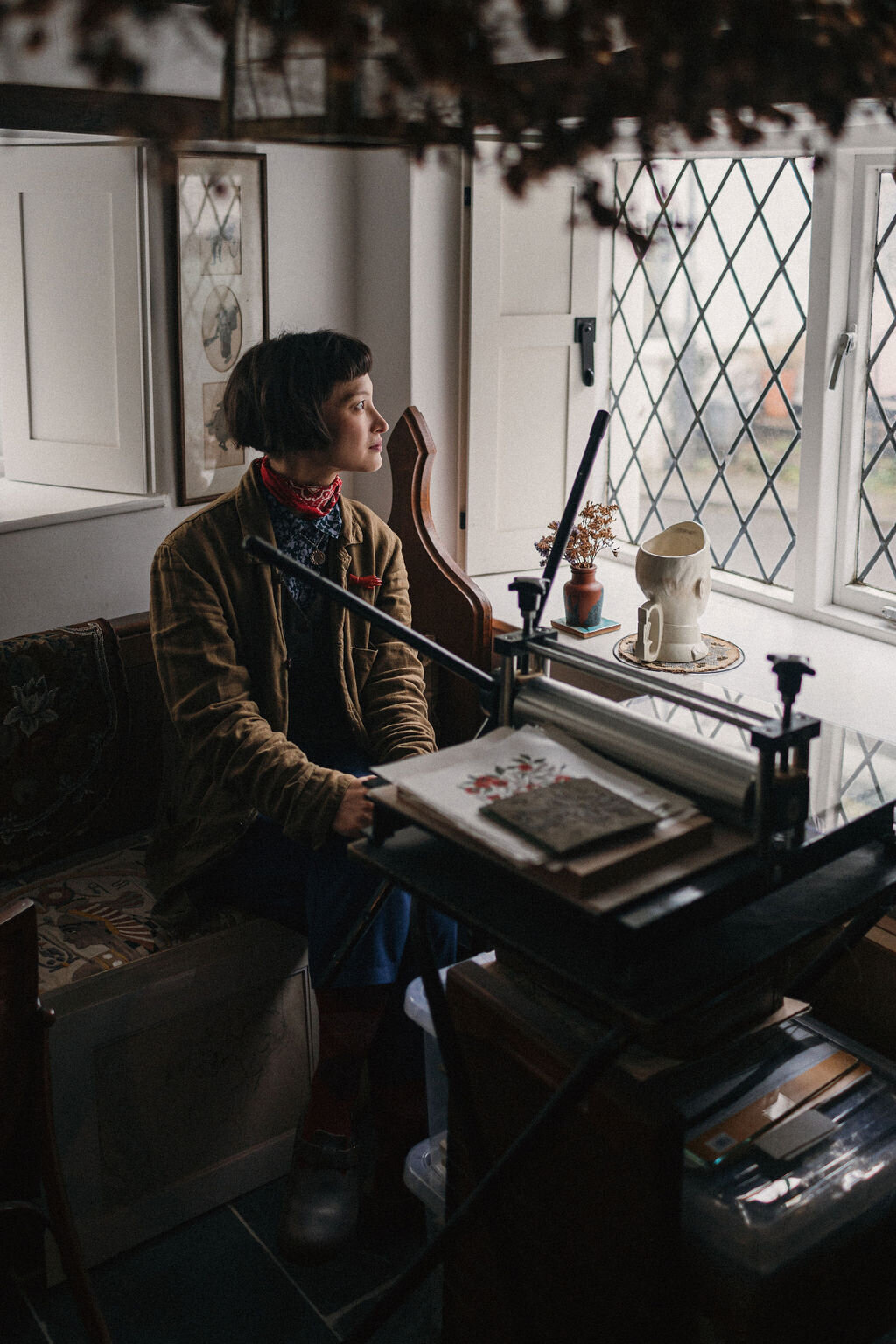 Portrait of Rachel Snowdon sat at her printing press in her home studio in mid Devon 