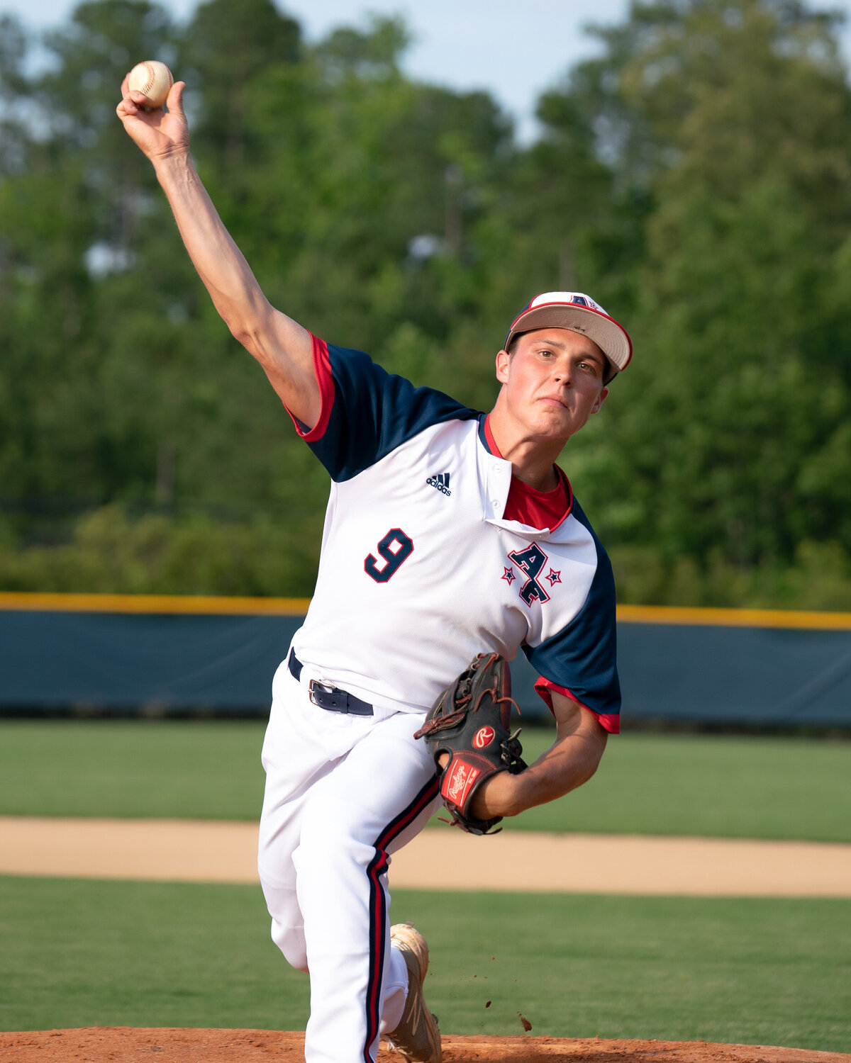 Closeup portrait of Connor Resavy throwing baseball towards camera and home plate. Captured at Apex-Friendship High School in Spring 2020