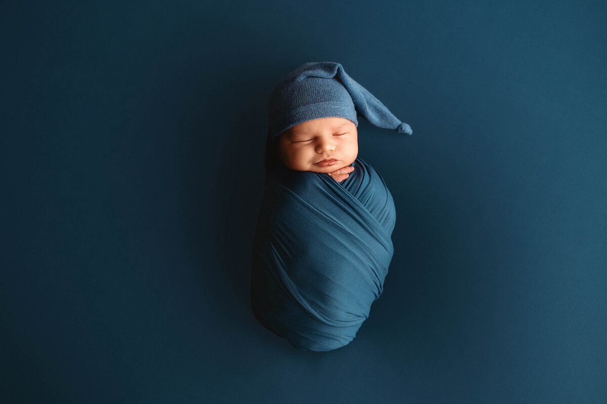 Charleston, SC #1 Newborn Photographer poses infant for Newborn Photoshoot in Charleston Portrait Studio.