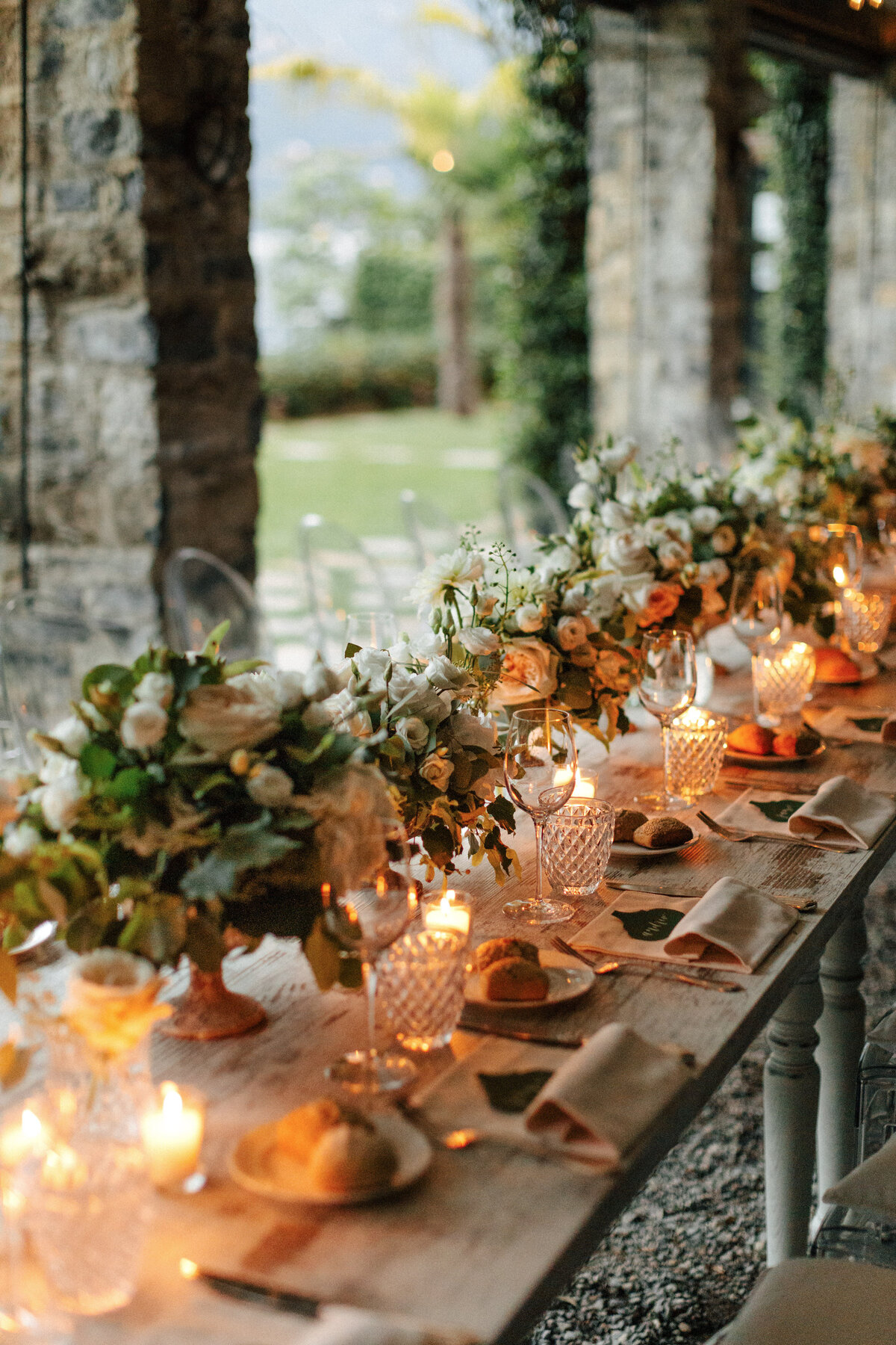 Lake Como Wedding Reception white florals long table with candles under roof