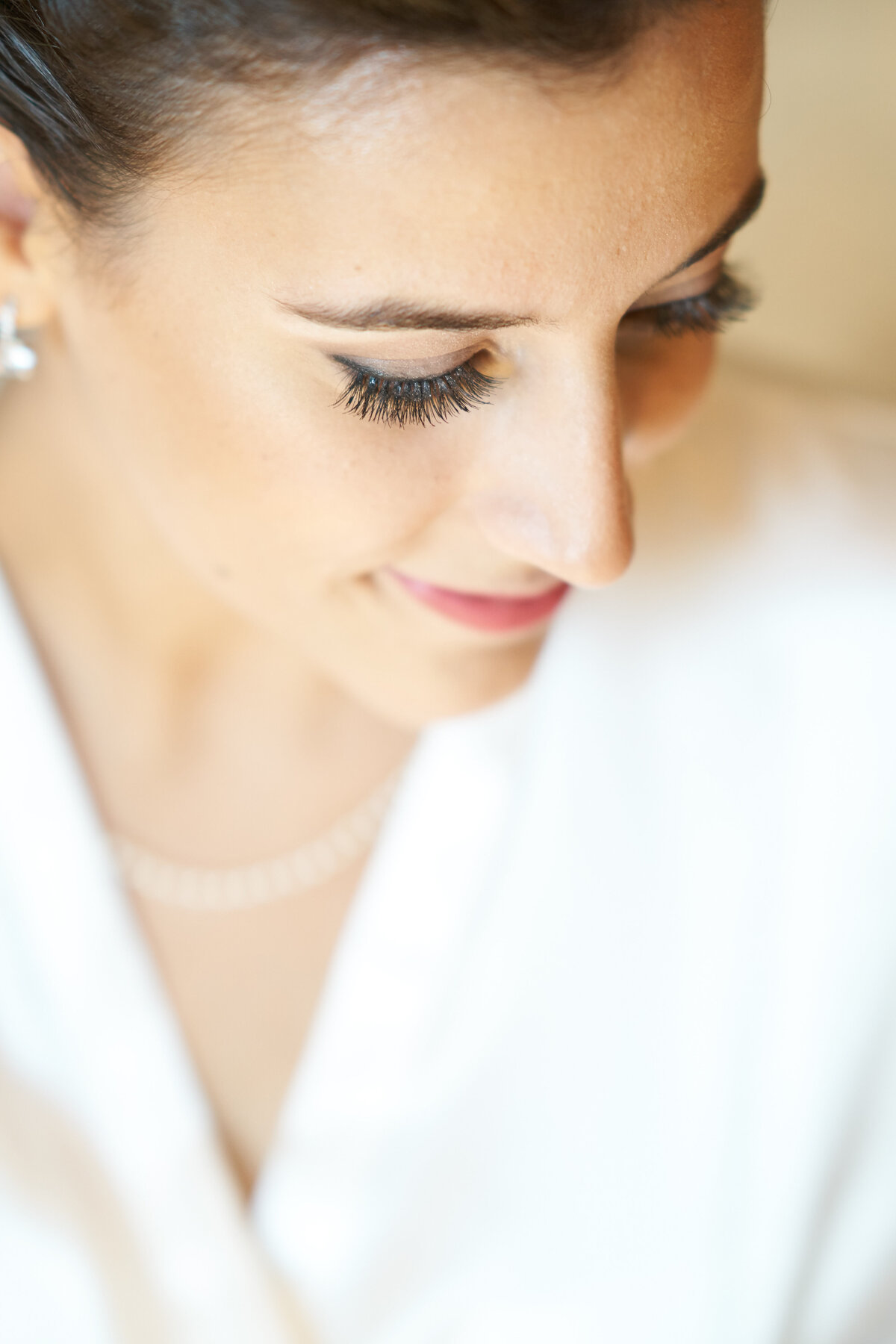 A close-up of a smiling bride highlights her radiant expression and elegant bridal makeup. This image captures the joyful and intimate moments of bridal portraits, showcasing the beauty and emotion that define our wedding photography.