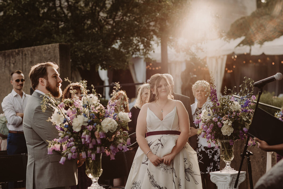 Guests on either side of an aisle watching during a wedding ceremony 
