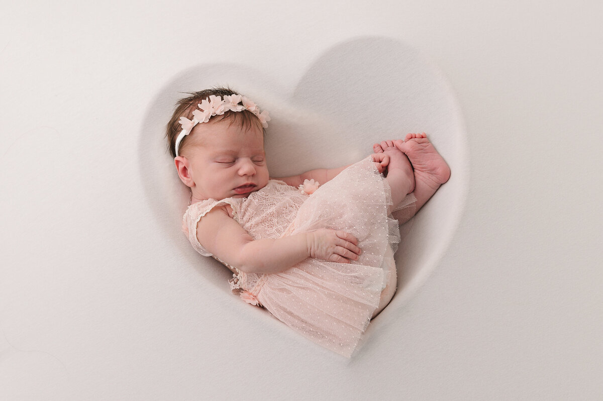 pasgeboren baby meisje op kussen in roze prinsessenjurkje uit de collectie van Nelly Biesemans
