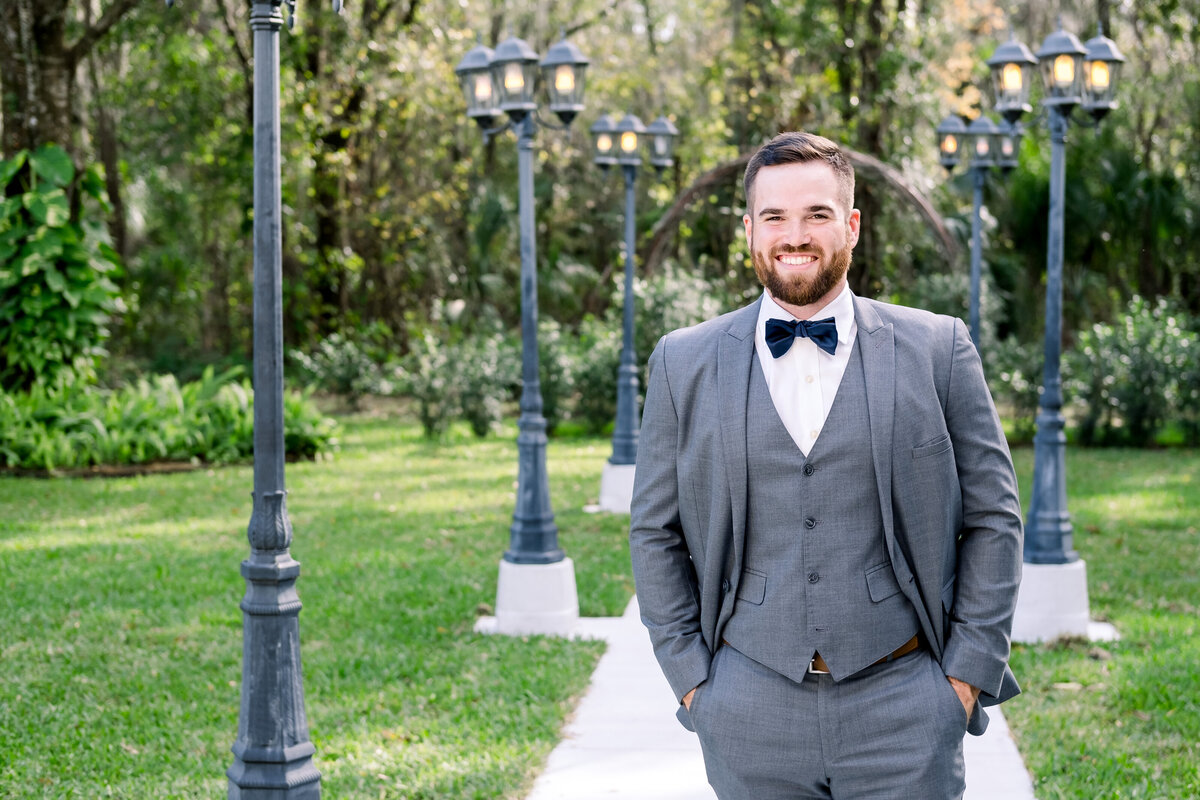 Groom in a gray three piece suit waits to see his bride for the first time in Tampa, FL