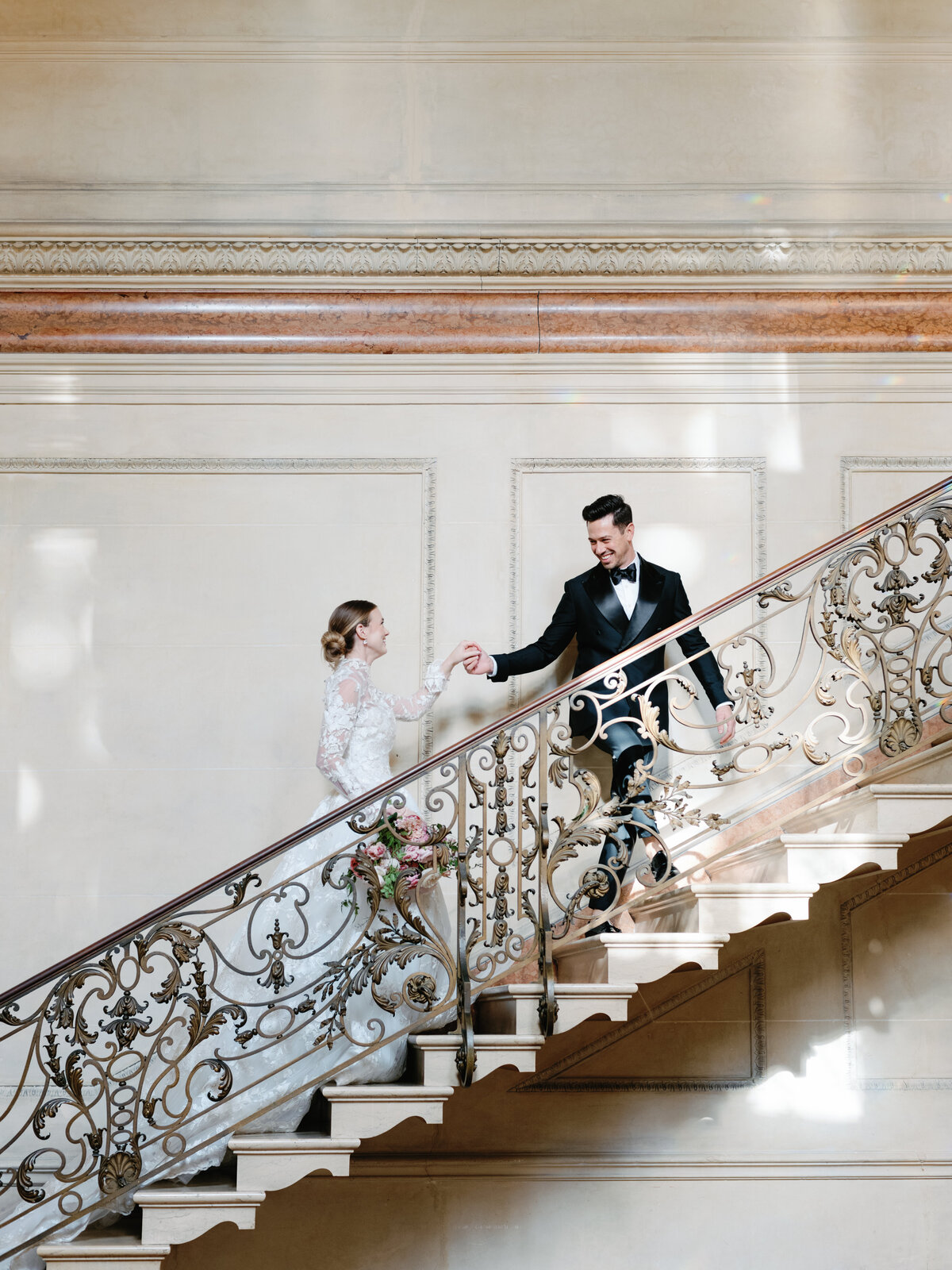 Bride and groom walking up the stair in Larz Anderson House