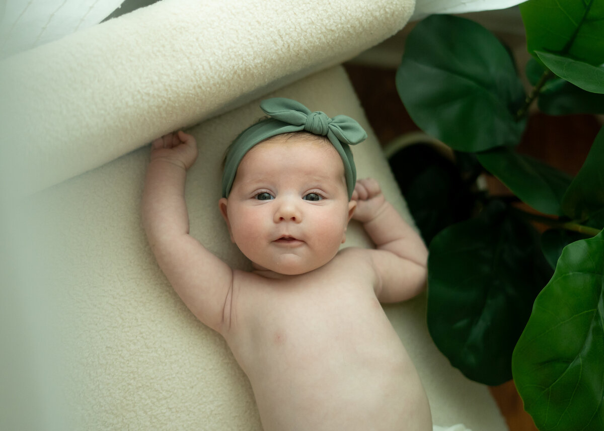 baby girl smiling wearing green headband lifestyle in studio newborn session Cleveland