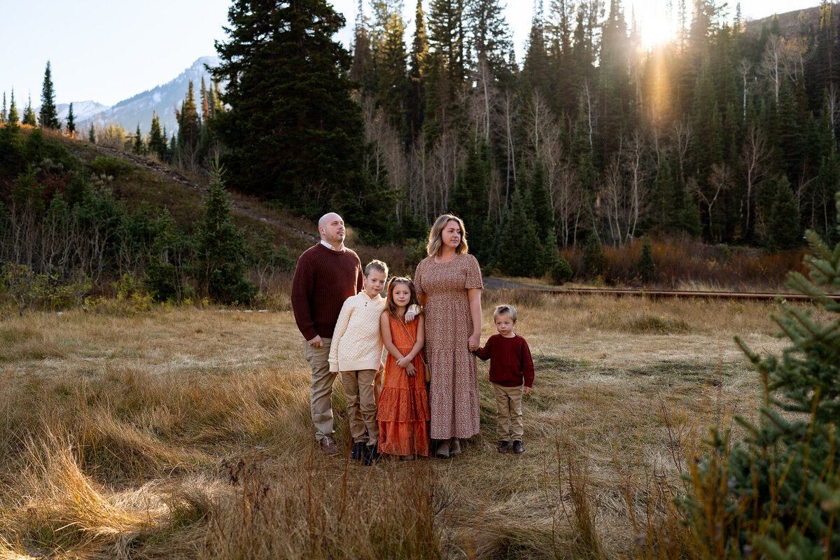 Family standing in a field in the middle of the mountains in Salt Lake City, Utah