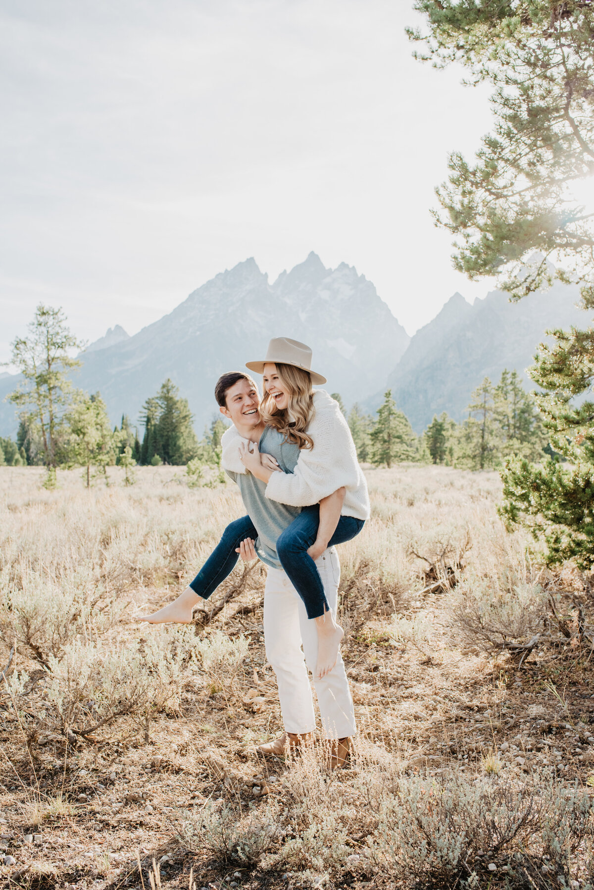 Photographers Jackson Hole capture woman on man's back during fall engagement photos