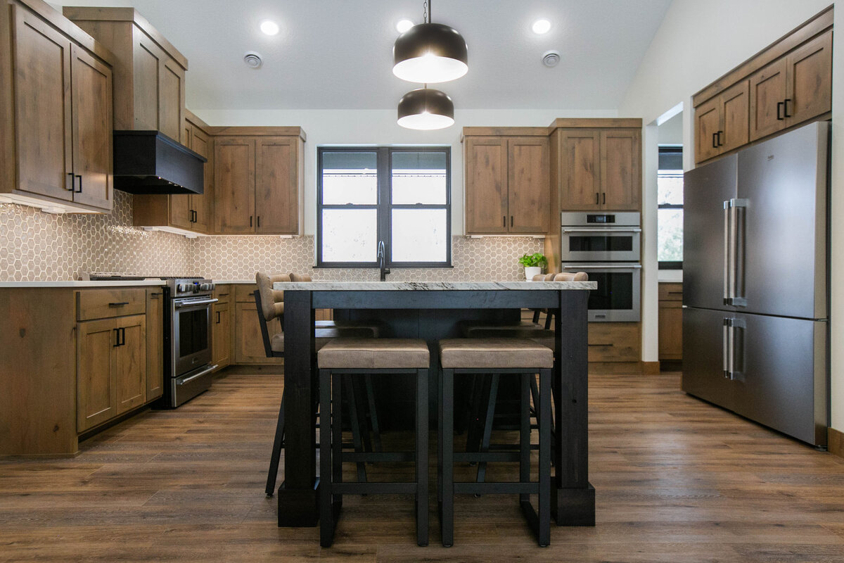Open kitchen with dark cabinets, large island, and quartz countertops in an Elk River custom home
