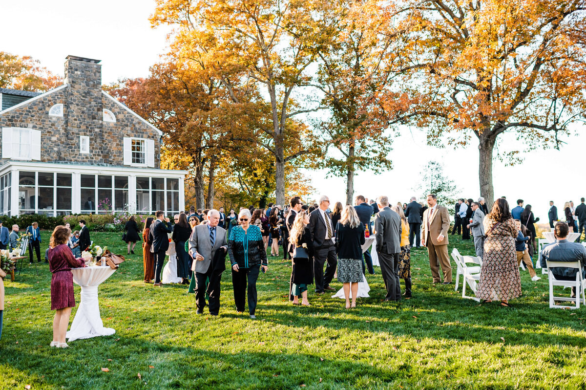 wedding guests wandering on a Charlottesville wedding venues lawn during cocktail hour