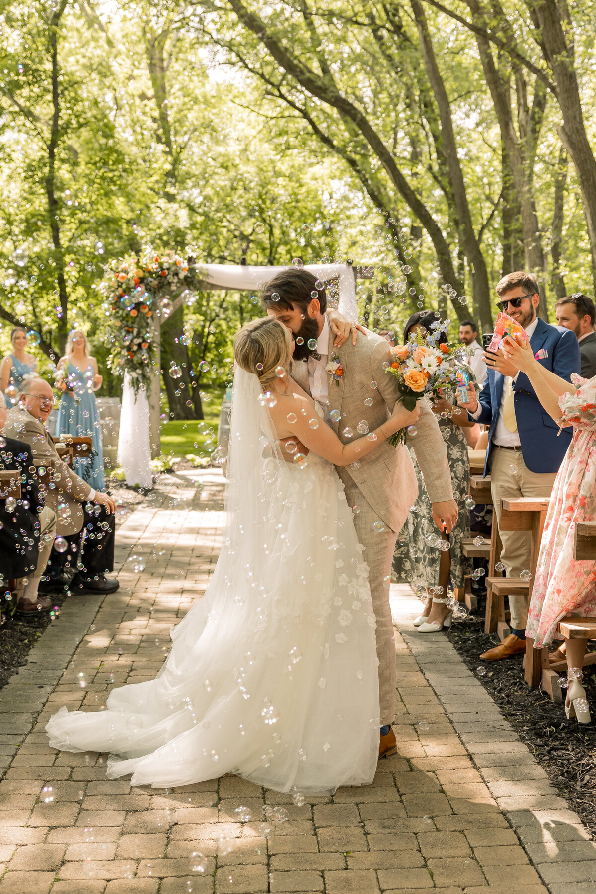 Bride and groom kissing down aisle at Carlos Creek Winery in Alexandria MN