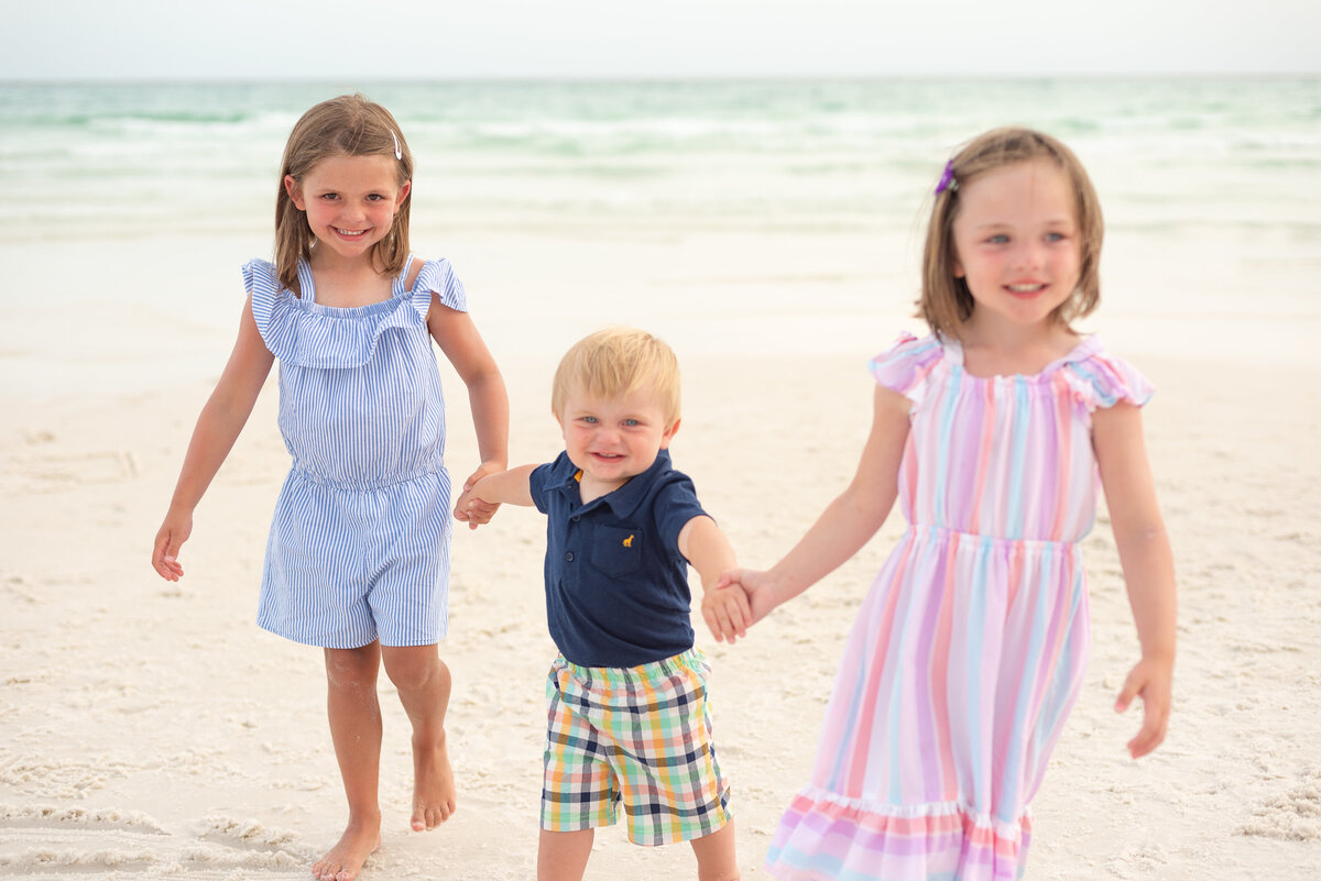 Three young kids posing for family portraits at beach photo by Michelle Lynn Photography located near Louisville, Kentucky