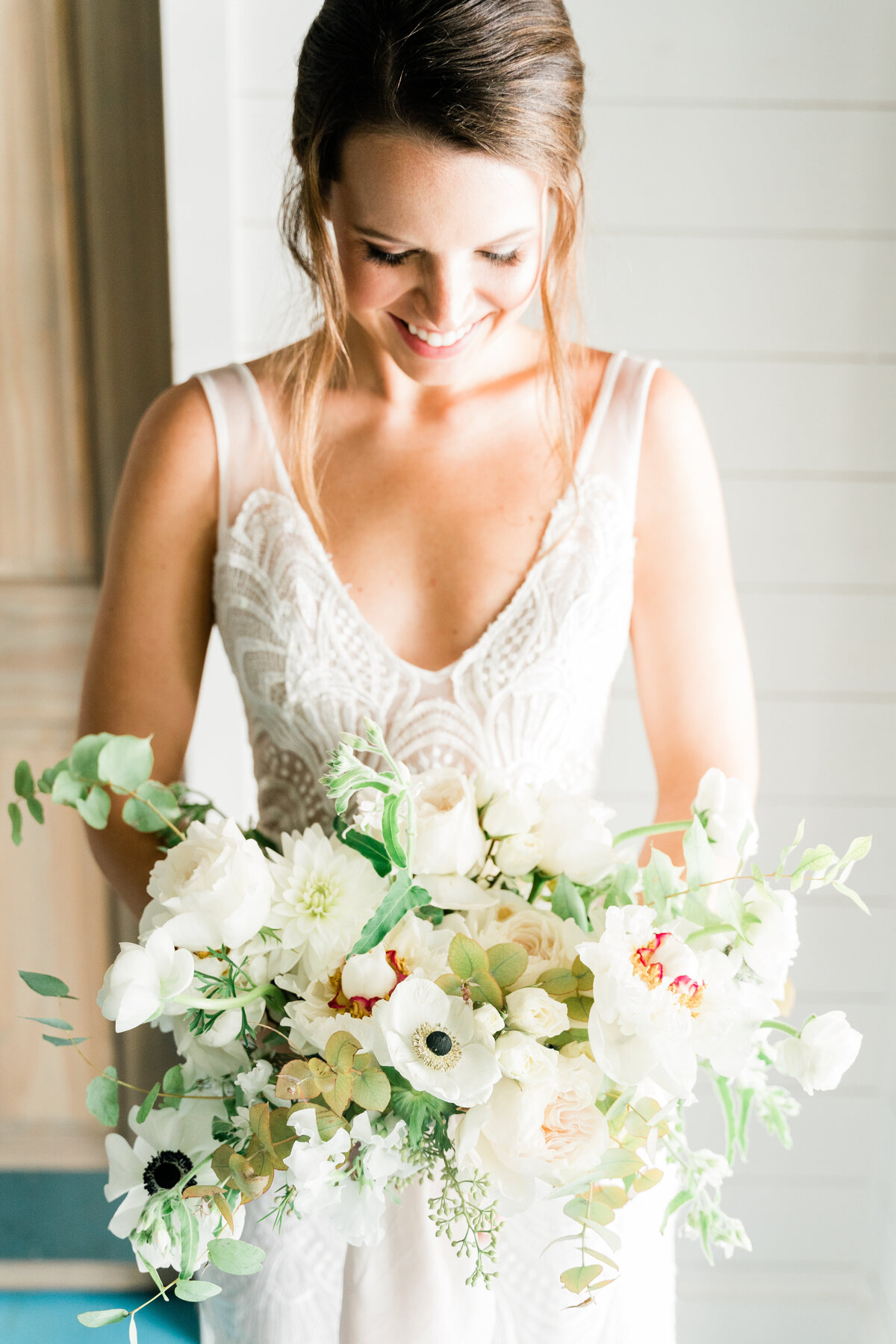 Bride looking at white bouquet