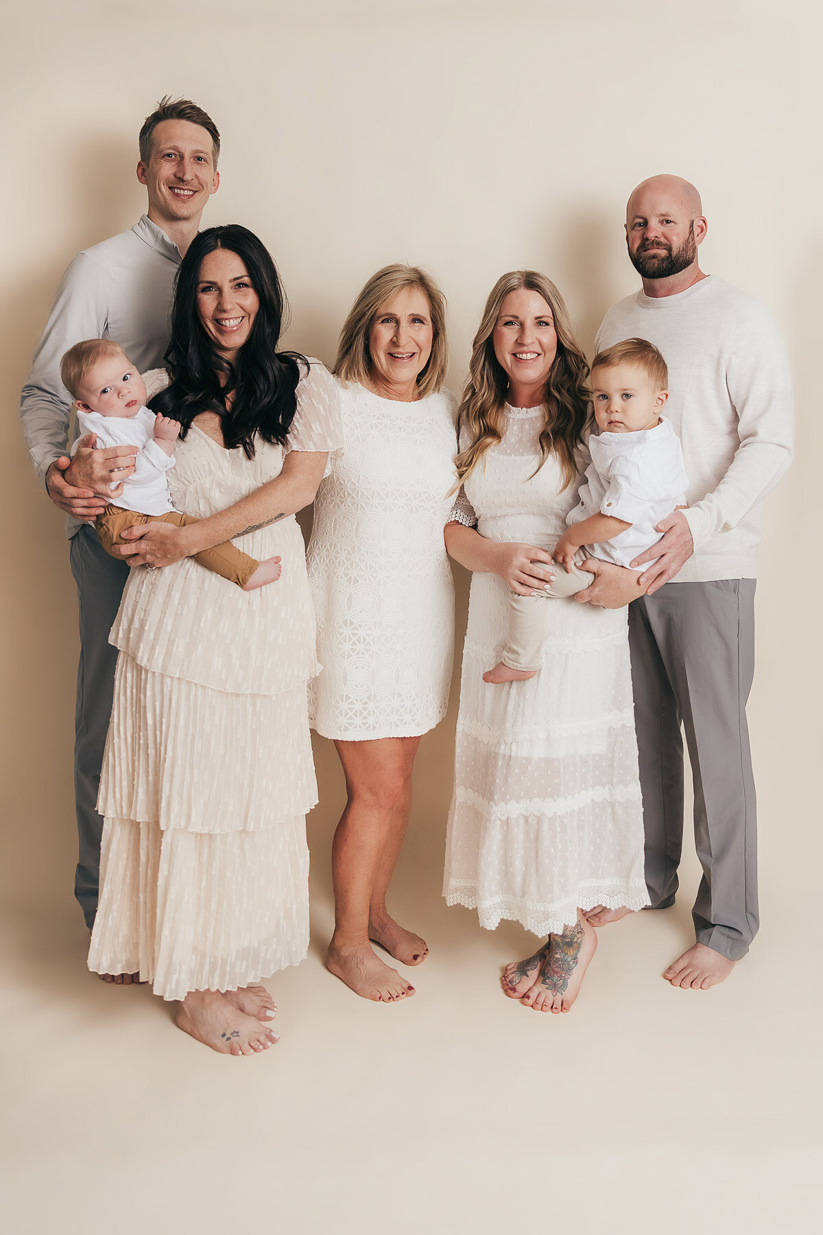 grandmother with adult children and grandchildren all standing and smiling together