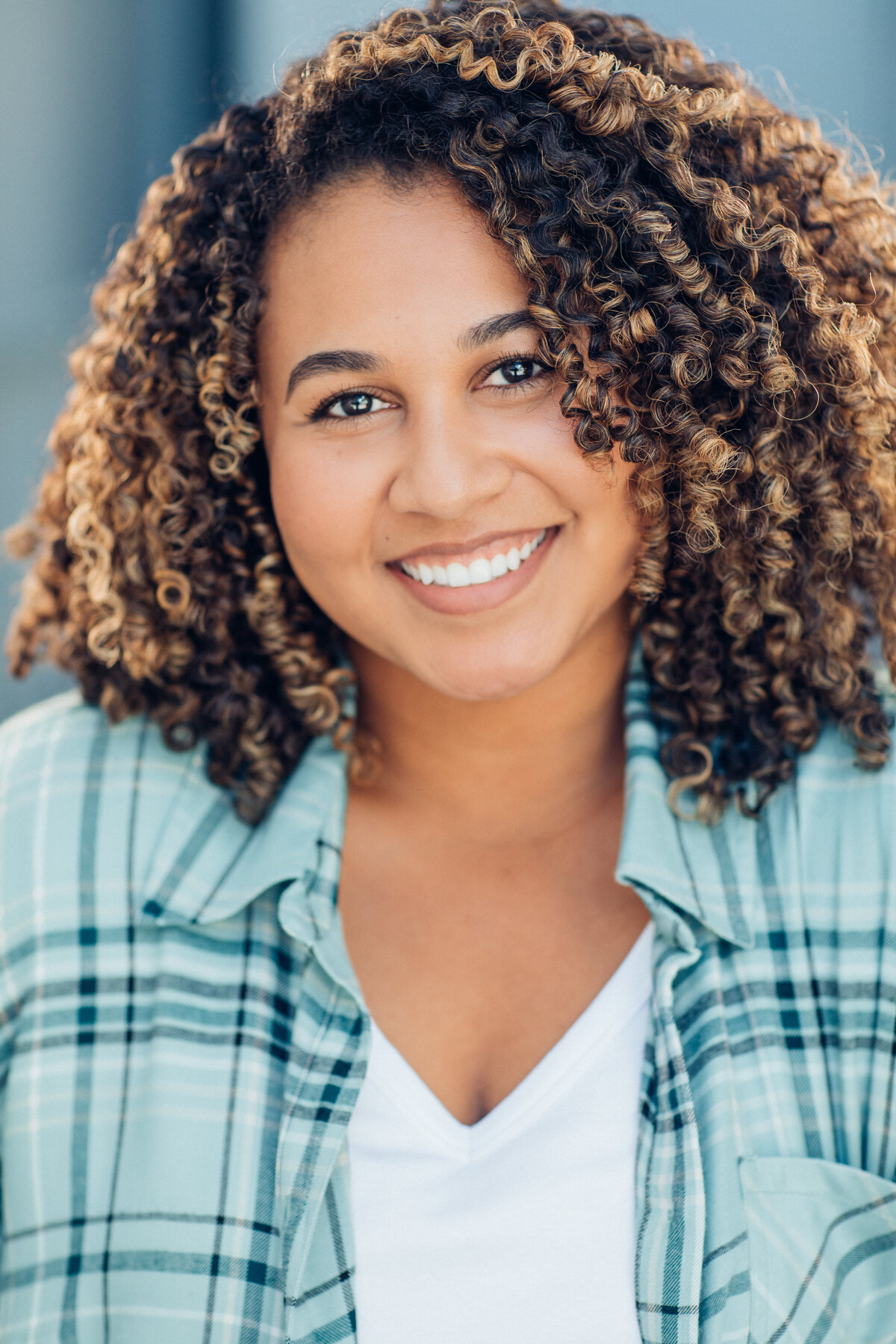 Headshot Photograph Of Young Woman In Outer Checkered Polo And Inner White Shirt Los Angeles