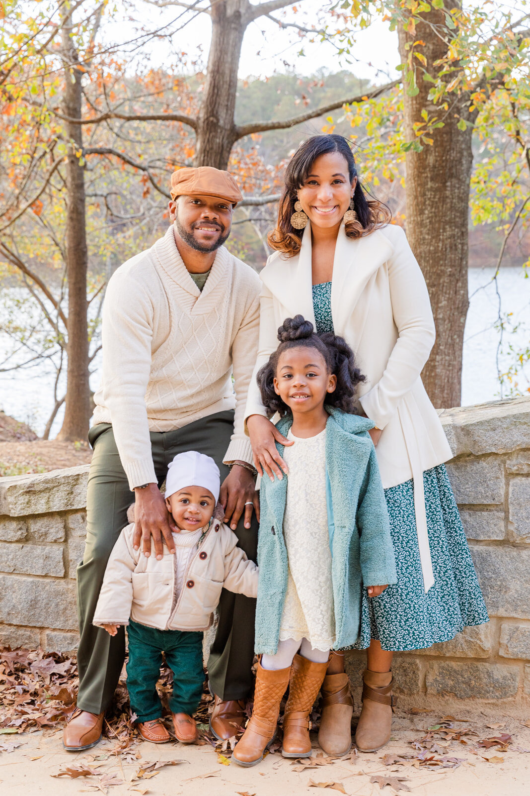brown skin family with two toddlers standing against a bridge in Brookhaven Atlanta GA