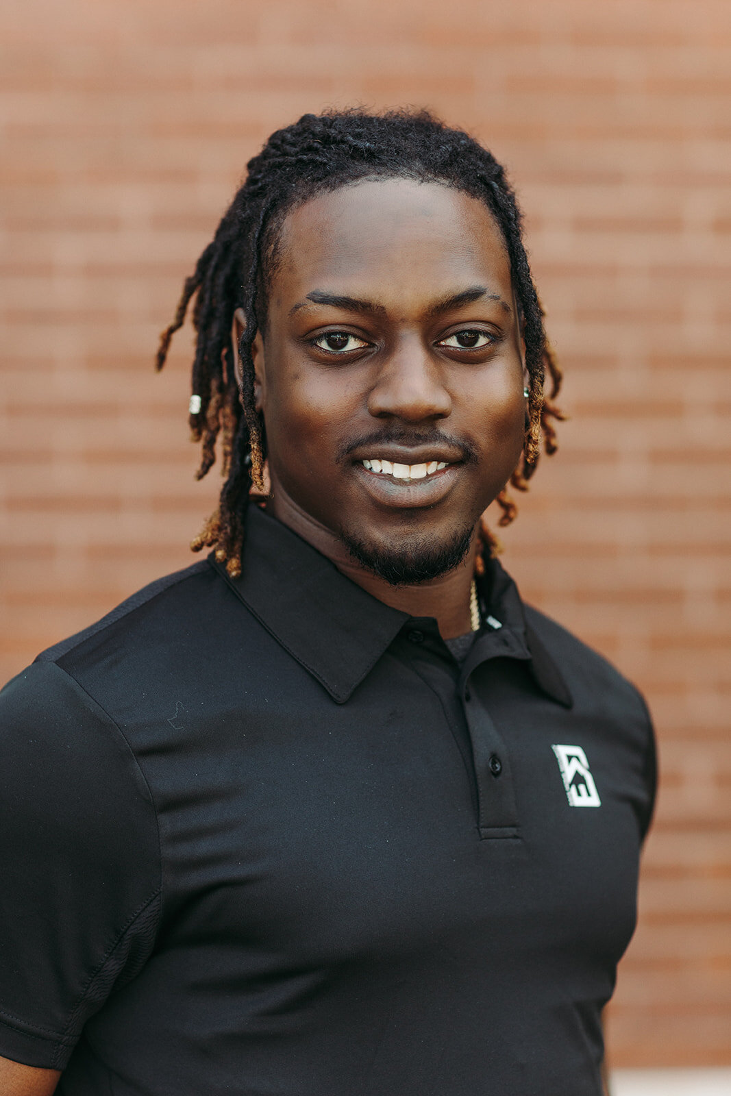 Utah Family Photographer captures man smiling wearing black team polo shirt while smiling