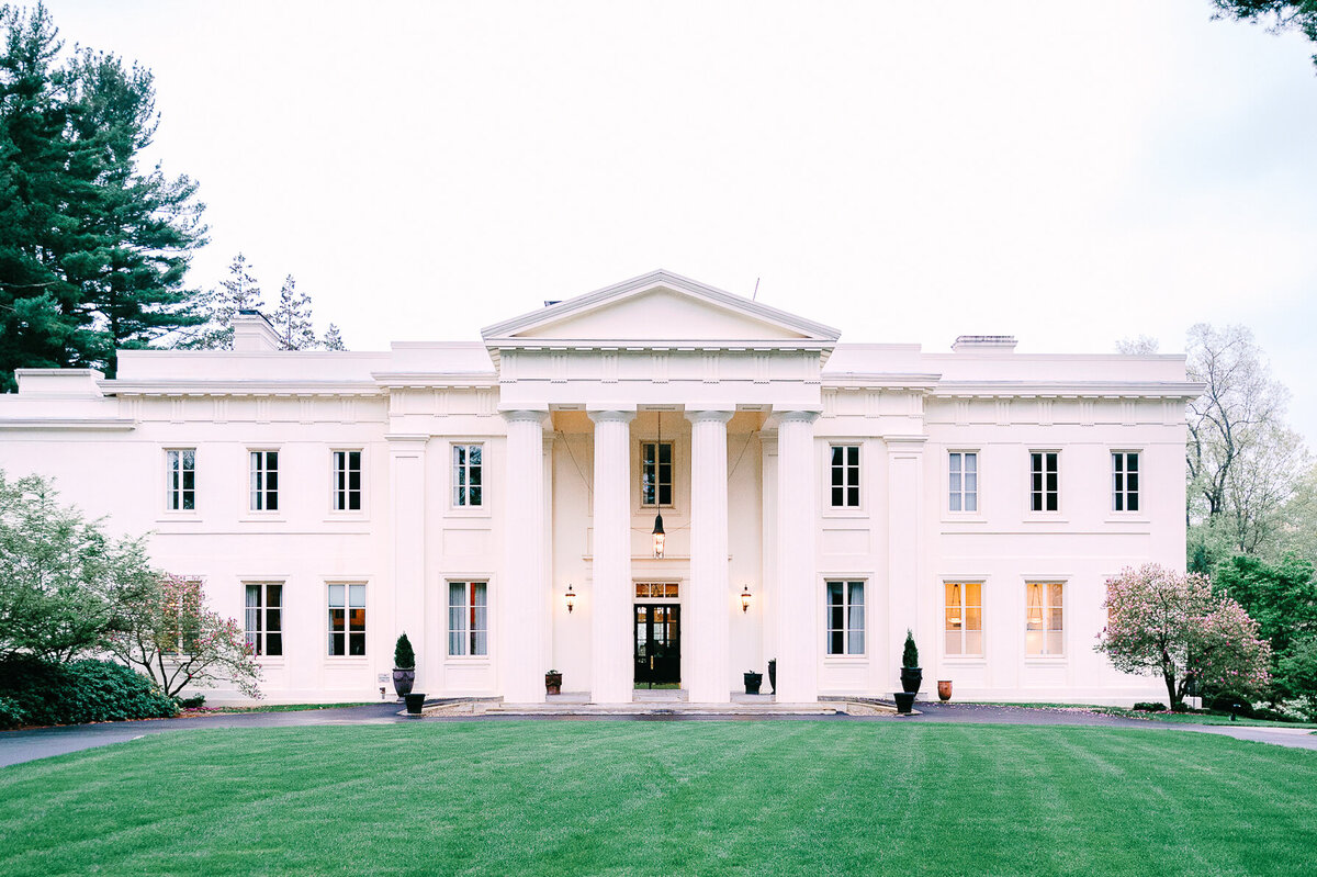 a grand white building with a green lawn